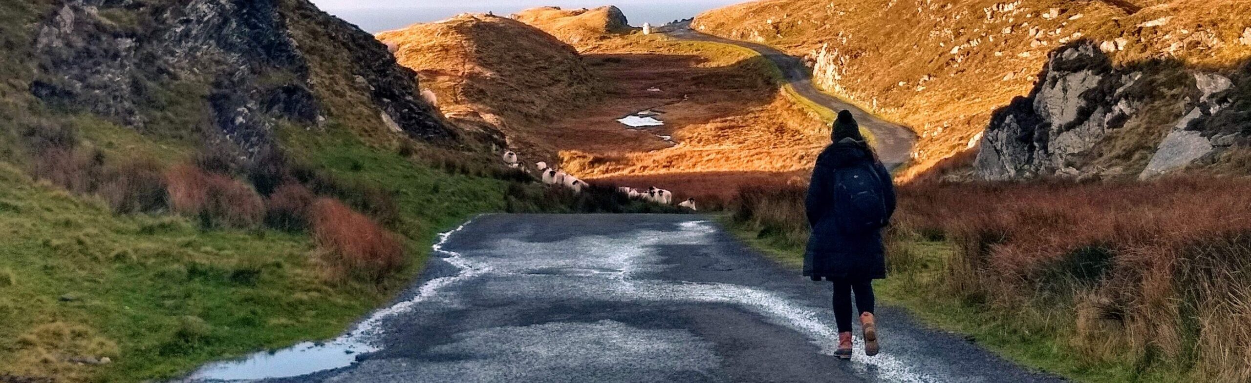 Woman walking down road in mountains